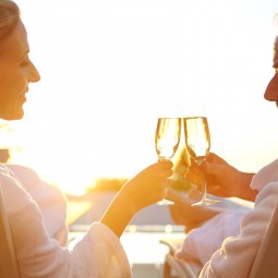 couple relaxing in chairs outside as they sip on wine