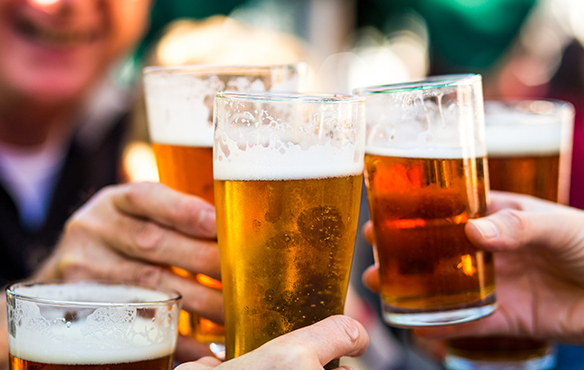 close up of people making a toast with beer