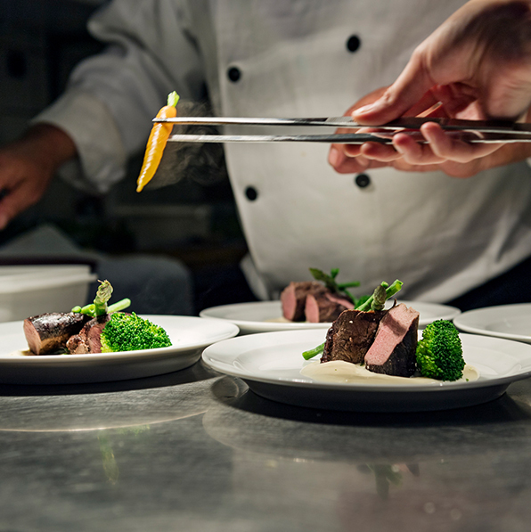 chefs plating steak dinners