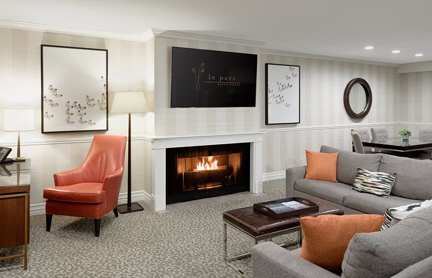 Living room space with TV, fireplace, couches, chair, and coffee table