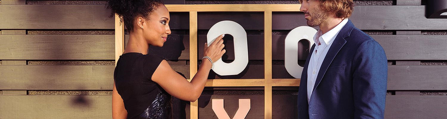 Woman holding a large O letter playing life size tic tac toe game