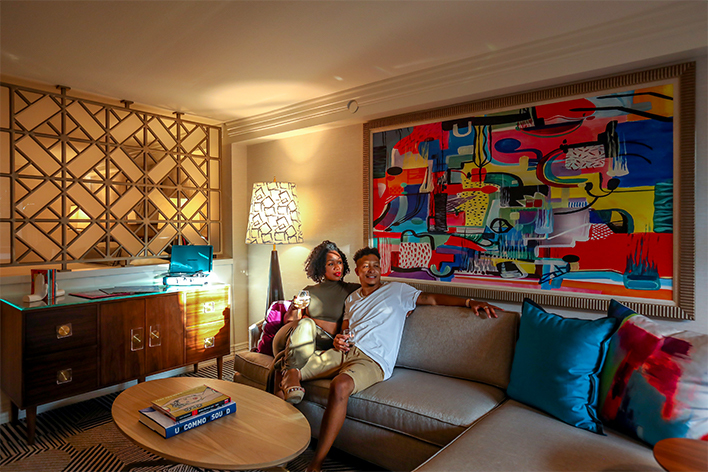 Couple sitting on a couch in their spacious Le Parc suite
