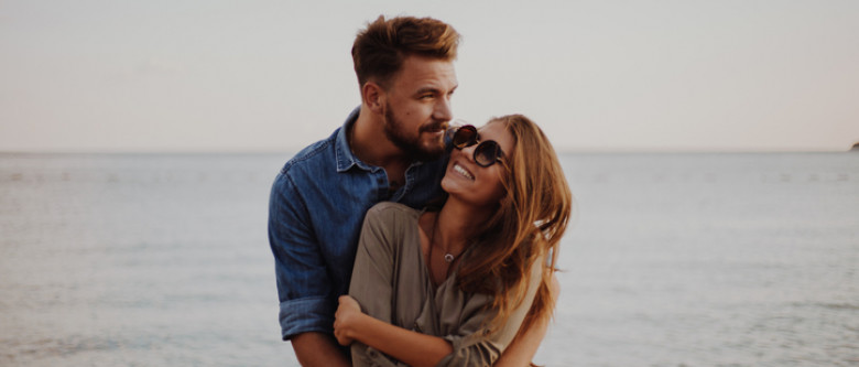 Couple hugging by the water