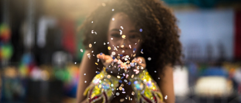 Woman blowing glitter at camera