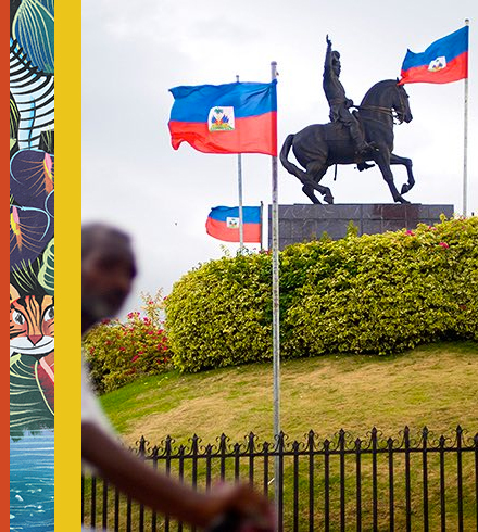 Steel statue of horse surrounded by Haitian flags