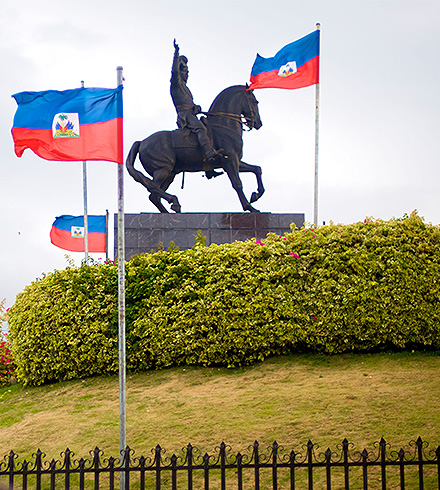 Steel horse statue surrounded by Haitian flags