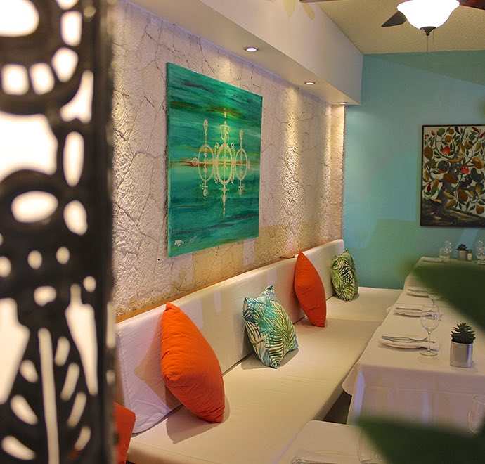 Dining area with white booth sitting area and colorful throw pillows