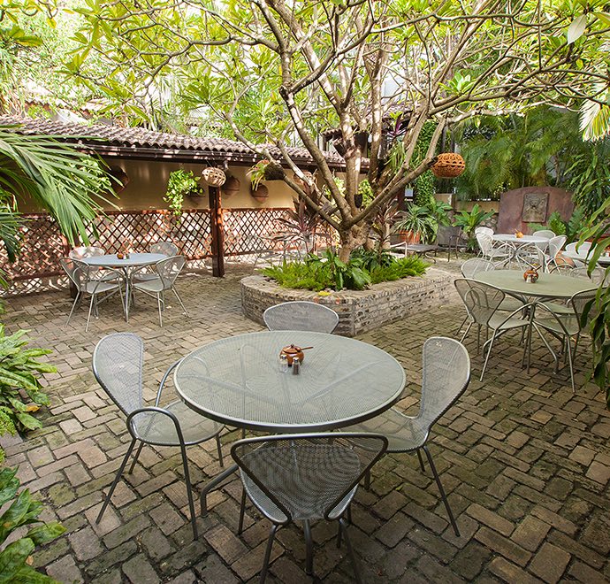 Hotel courtyard with brick flooring and glass tables