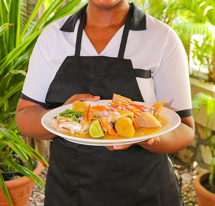 Close up of staff member holding dish of food