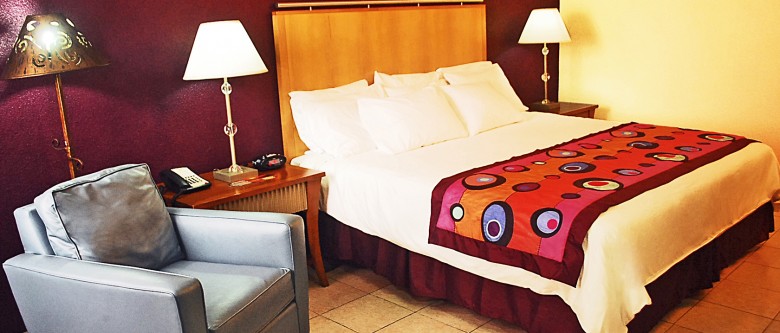bedroom with one bed, two lamps and nightstands, and a chair