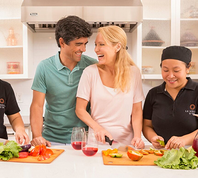 Couple preparing a meal with chefs