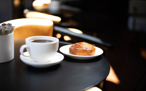 table with coffee mug anad pastry on it
