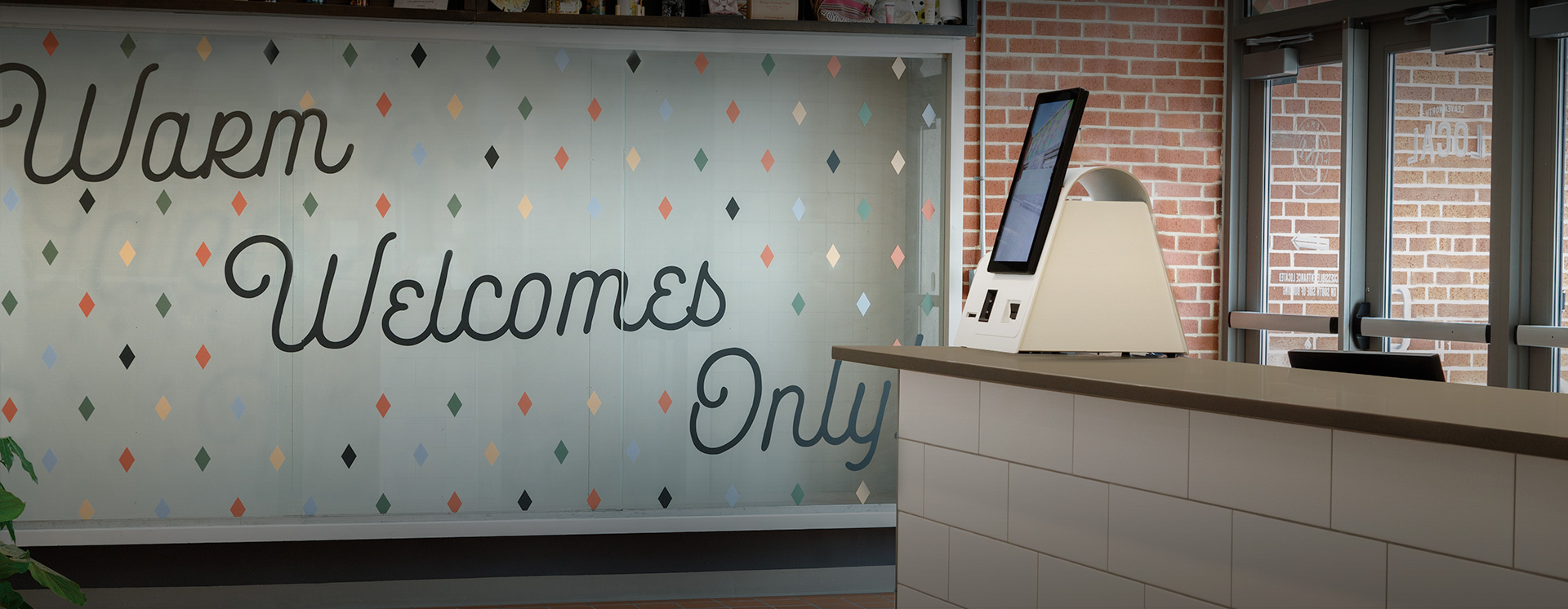 hotel reception with sign behind saying warm welcomes only