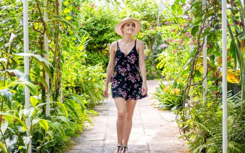 young woman in sundress exploring the resort along a cobblestone path
