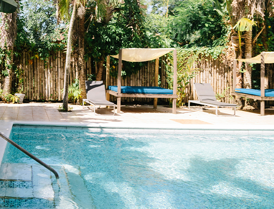 serene cabana shaded by palm trees along a resort pool