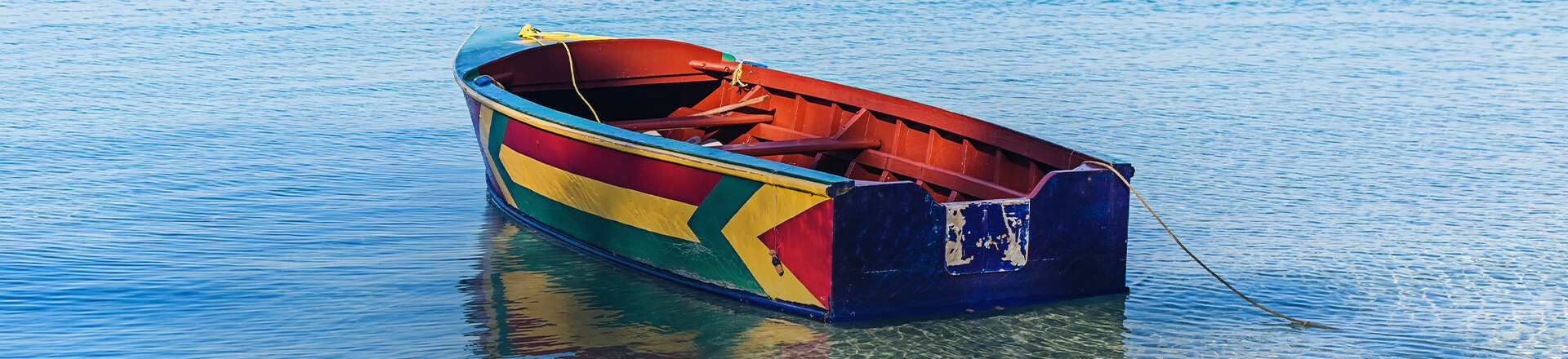 colorful rowboat floating anchored near shore