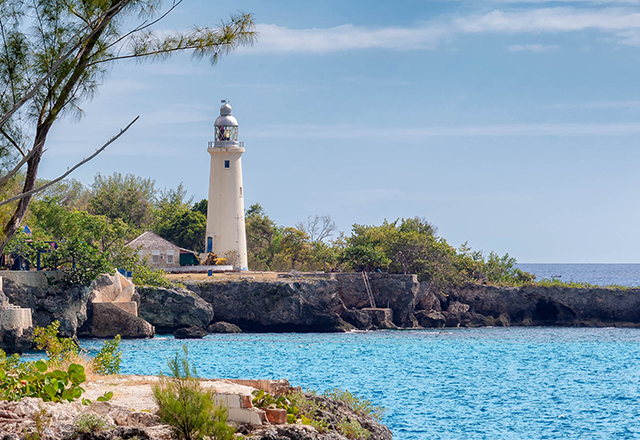 regal white lighthouse on cliff overlooking calm ocean waters