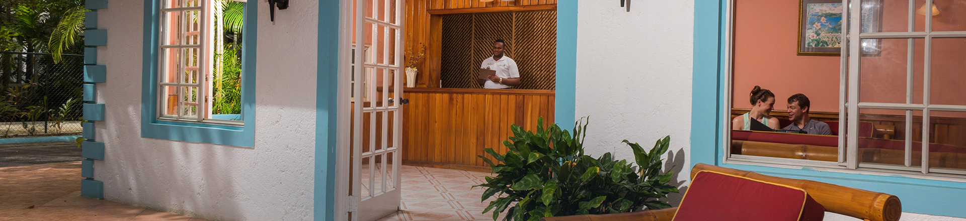 open and airy welcome reception desk of Legends Resort with welcoming male employee at desk
