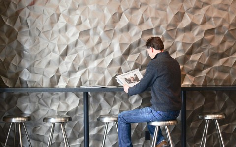 a person reading the newspaper at a bar