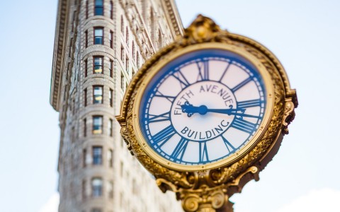 fifth avenue building clock with the flat iron building in the background