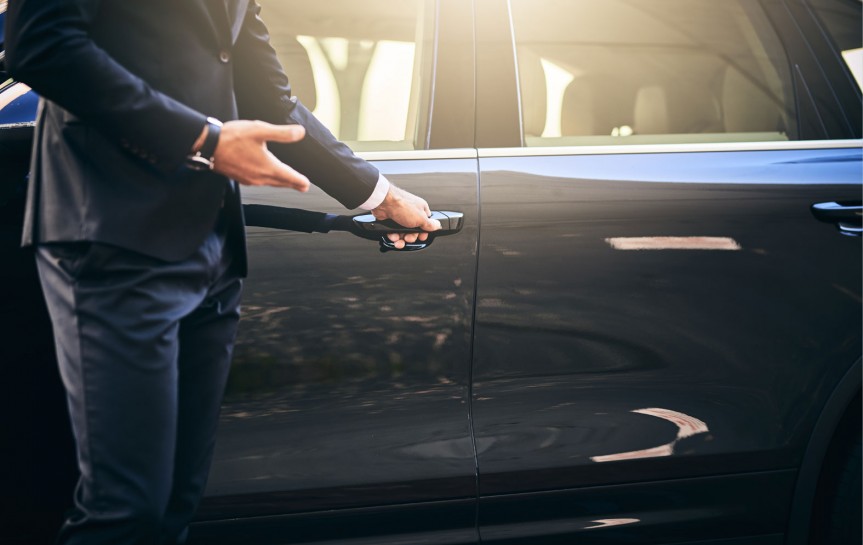 close up of man in a suit opening a car door
