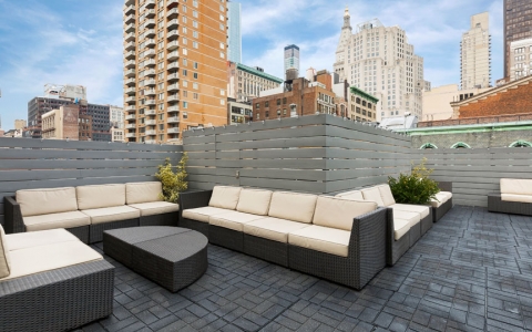 couches in rooftop lounge with view of city around