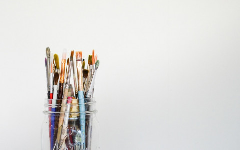 Clear Mason Jar holding a variety of paint brushes