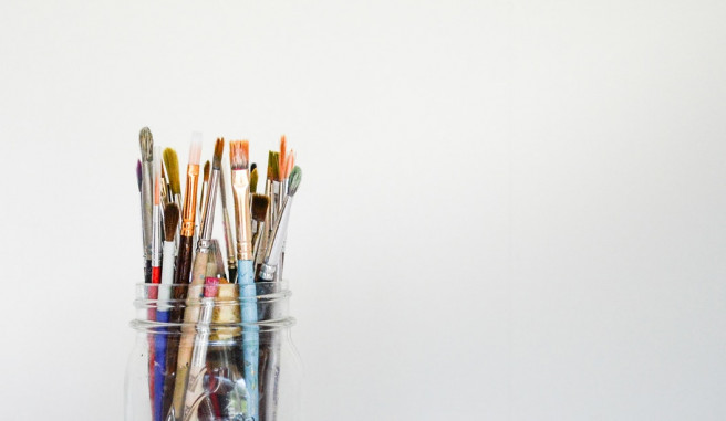 Clear Mason Jar holding a variety of paint brushes