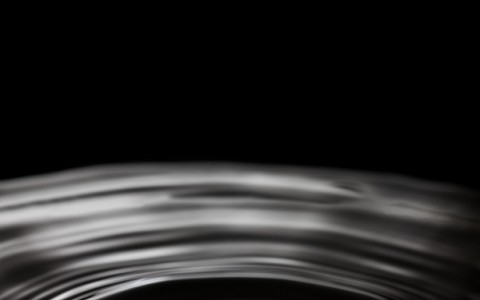 dropping water bubble ring waves on black splashing background