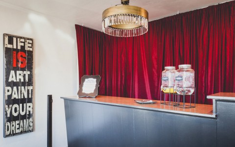 lobby desk with theater red drapes behind and retro chandelier