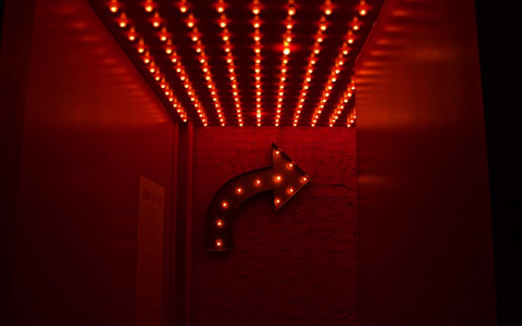 red arrow with lights in a red room pointing to the stage