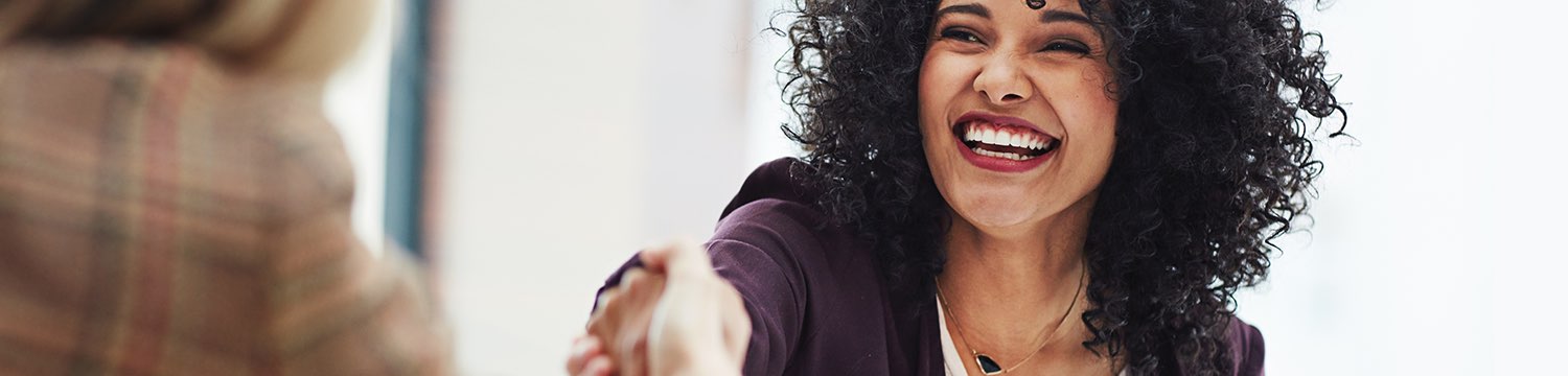 Woman reaching to give other woman a handshake