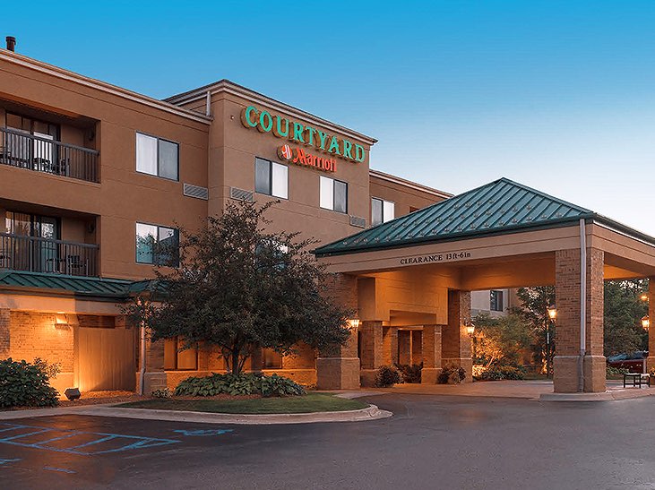 Courtyard Marriott brick building with green roofs lit up at night
