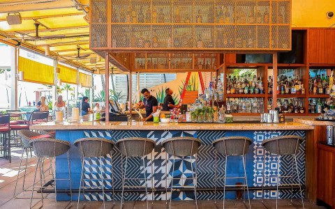 outdoor bar area with 2 bartenders working