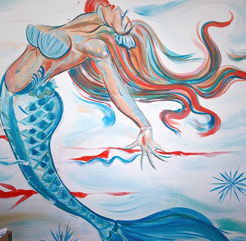 Painted wall mural of mermaid and ocean