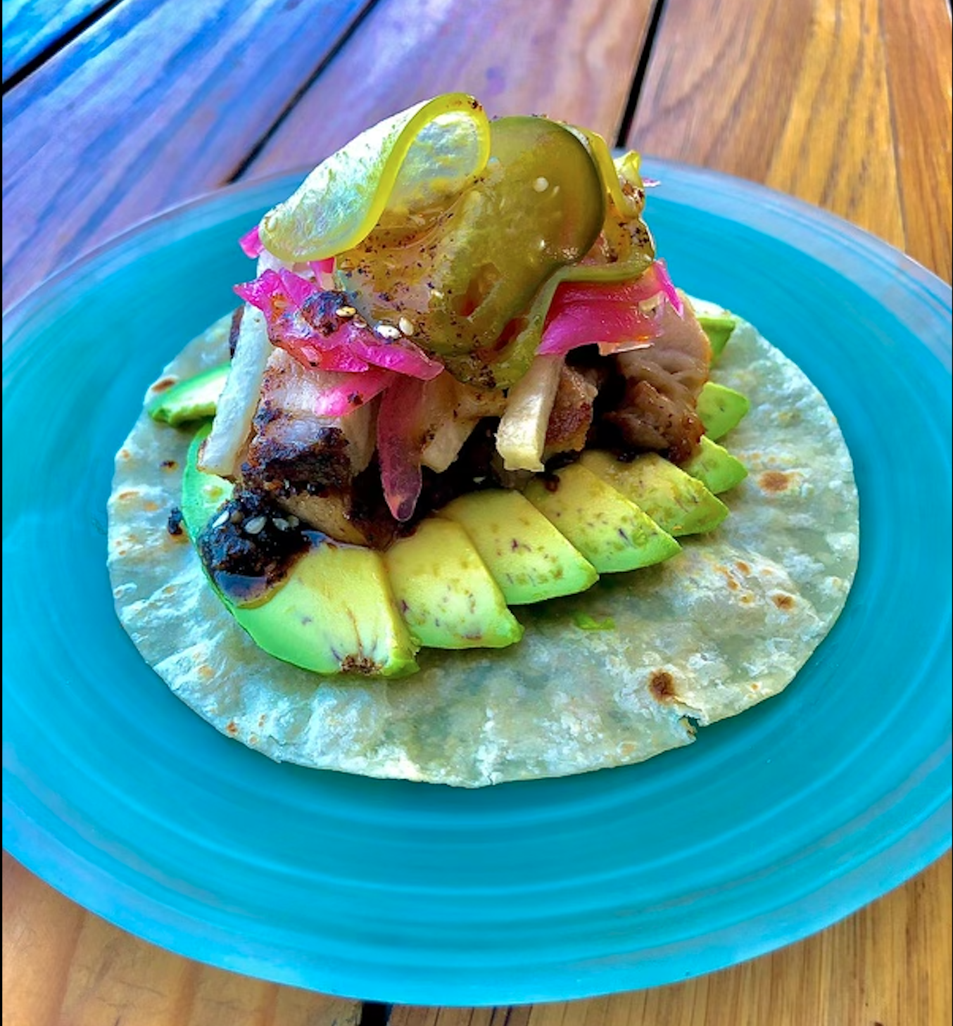 Taco with avocado and pickles