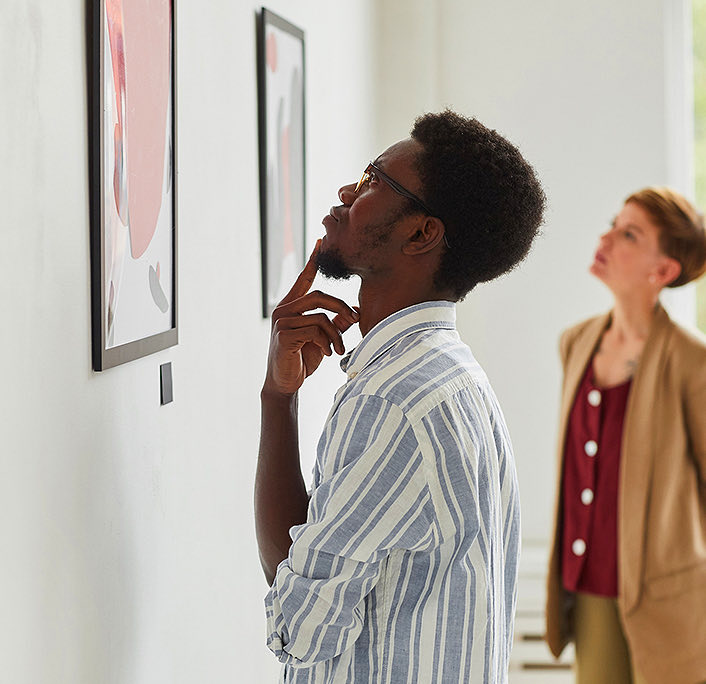Close up of a man analyzing a painting at a art gallery