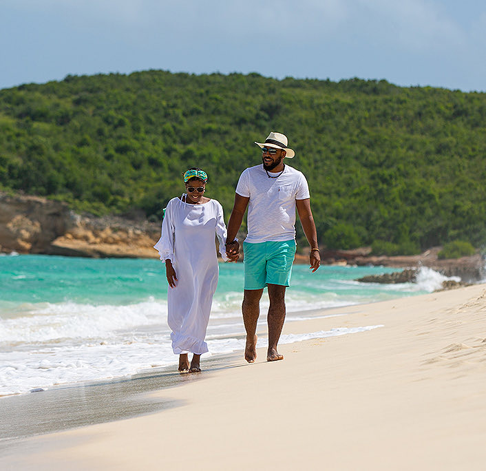 A lovely couple holding hands while walking at the beach
