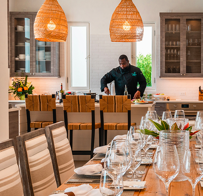 View of a dining area with elegant decoration and a chef cooking on the background