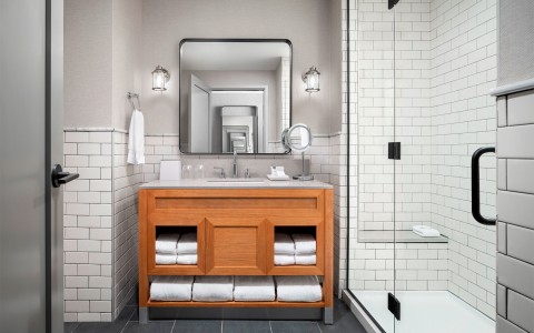 view of a gray bathroom with a walk in shower and wooden vanity