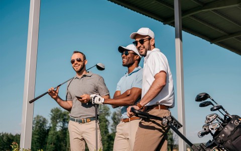 three well dressed male golfers smiling