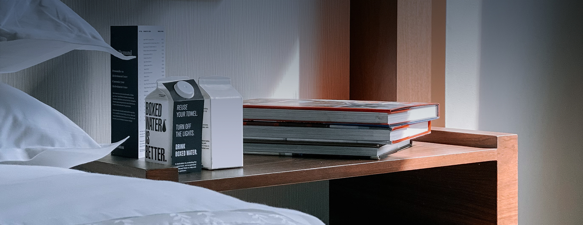 view of a nightstand with books and drinks in cartons on top