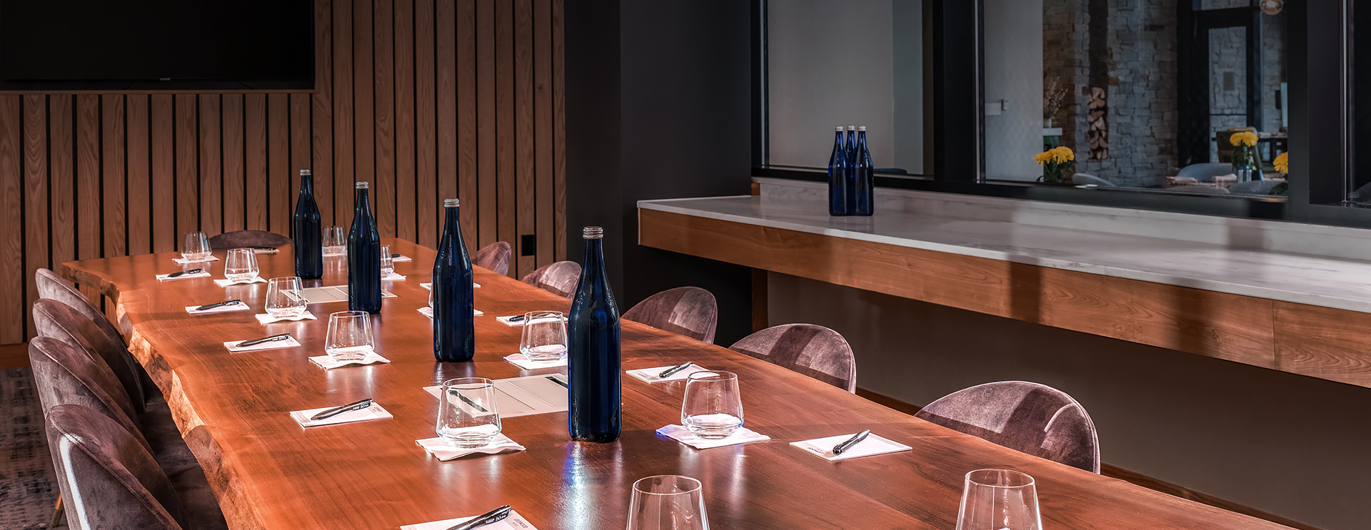 a large wooden table with elegant blue bottles and empty cups on top of it