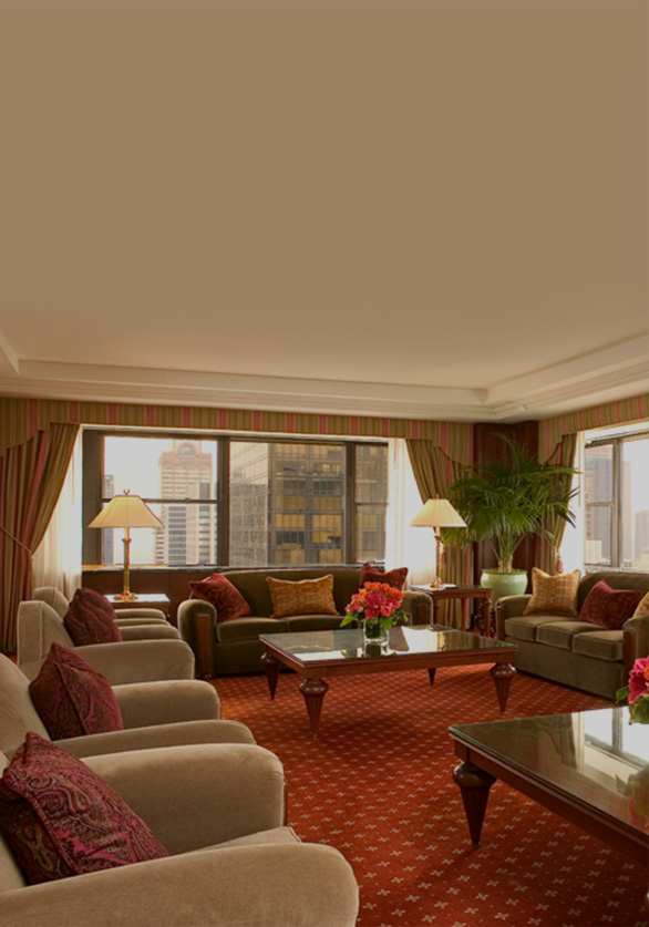 Towers Three Bedroom living room with beige couches with red accent pillows & new york city views