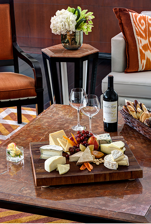 Cheese platter accompanied by wine and two wine glasses