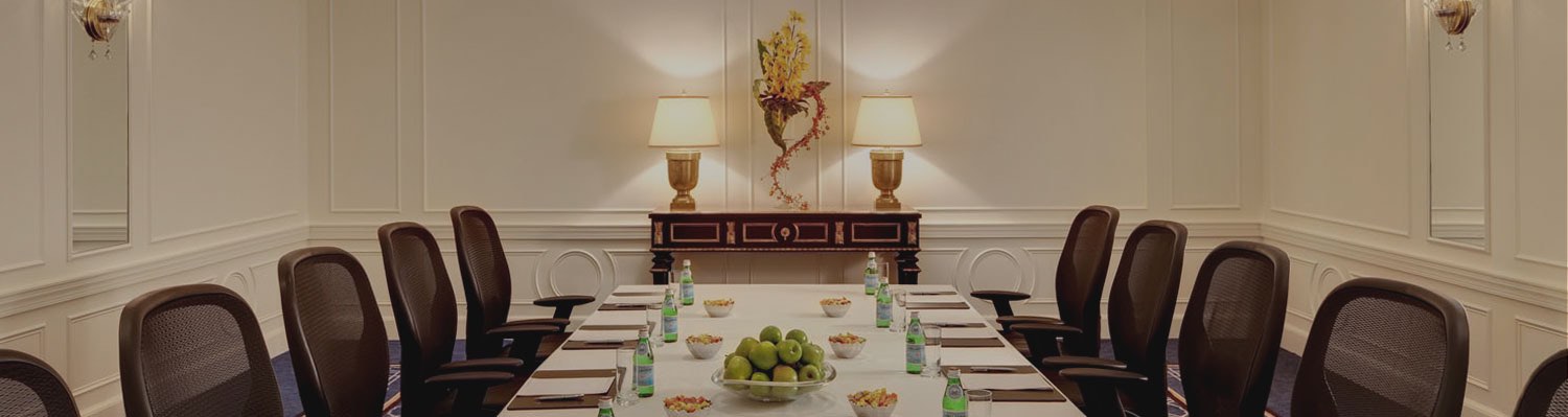 Long table with chairs set up with notepads, snacks & drinks