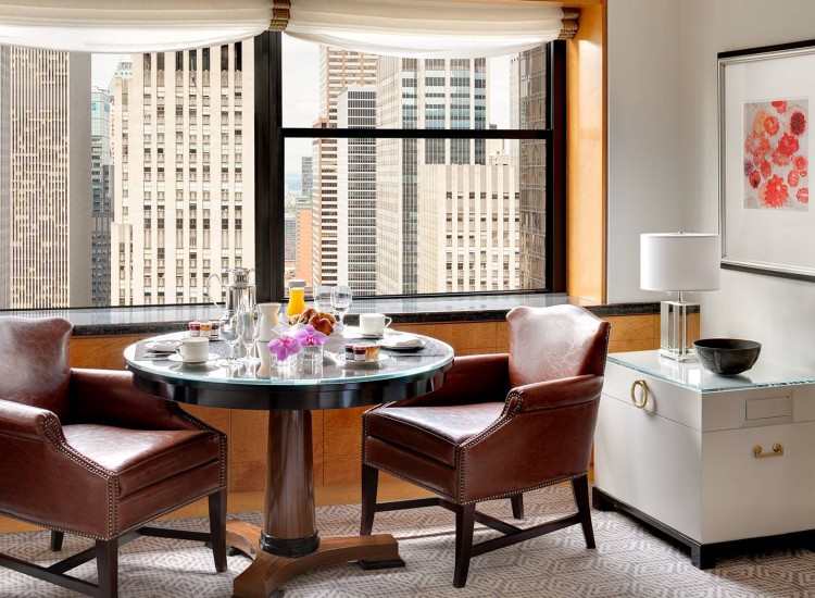 Table set for breakfast next to window overlooking city