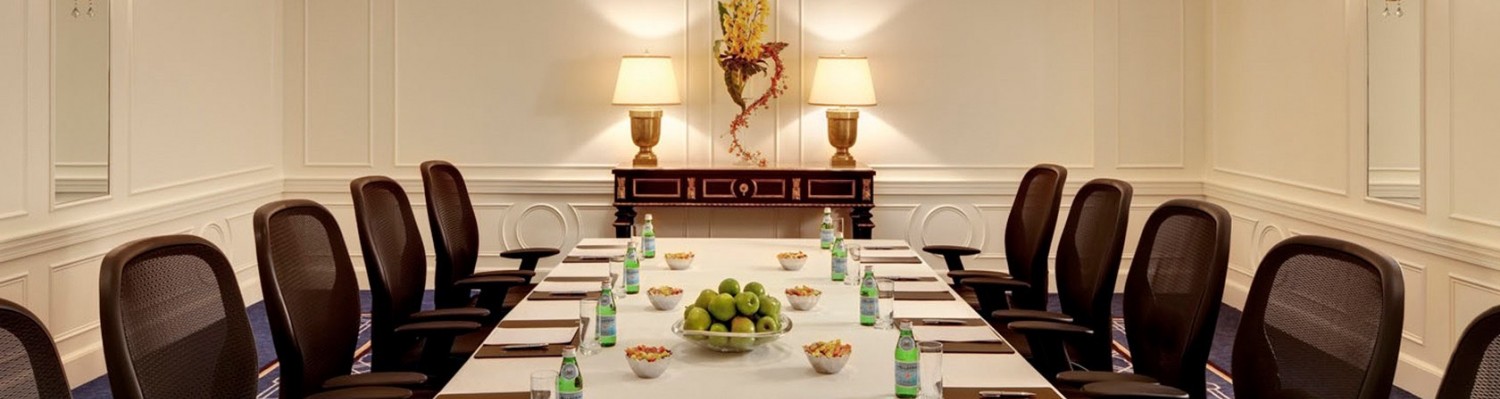Long table with chairs set up with notepads, snacks & drinks