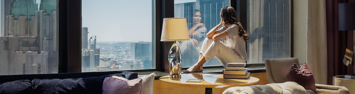 woman looking out the window in pajamas