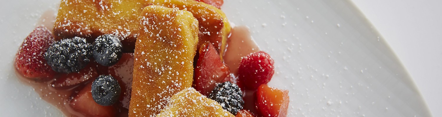 french toast with assorted berries and powdered sugar